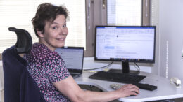 Toimintakoordinaattori Katriina Lehtovaara työskentelee työpisteellään tietokoneen ääressä.